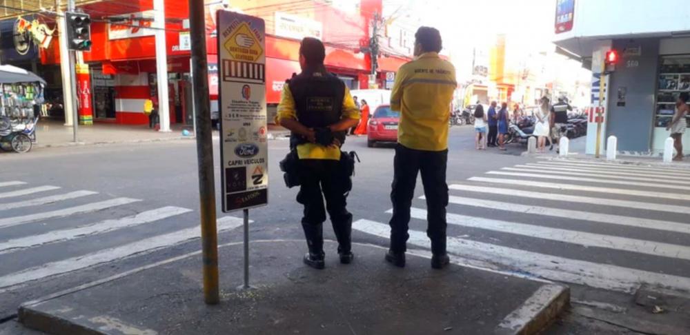 Agentes de trânsito fiscalizam travessia em faixas de pedestres na área comercial